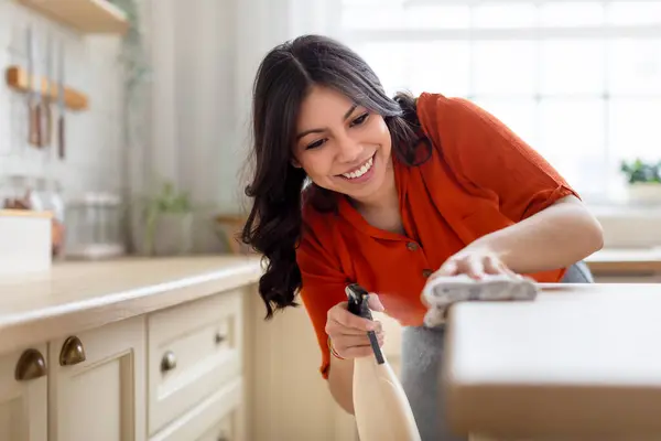 Kobieta Gospodyni Domowa Żartobliwie Sprząta Blat Kuchenny Pokazując Pozytywne Nastawienie — Zdjęcie stockowe