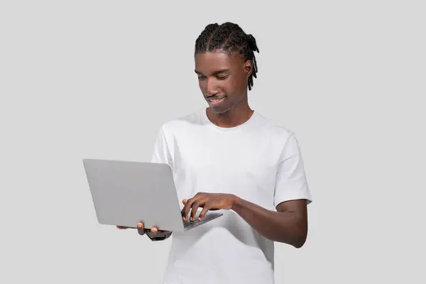 Obraz Ten Przedstawia Afrykańskiego Amerykanina Uważnie Przeglądającego Laptopa Odizolowanego Białym — Zdjęcie stockowe