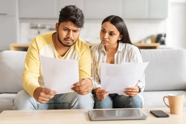 Eastern Millennial Couple Looks Closely Financial Documents Displaying Expressions Concern — Stock Photo, Image