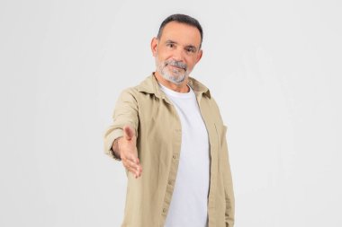 Friendly old man extending a hand for a handshake, isolated on a white background, suggests welcome and cooperation clipart