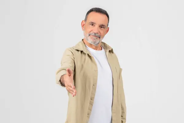 stock image Friendly old man extending a hand for a handshake, isolated on a white background, suggests welcome and cooperation