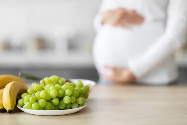 Mutfakta Besleyici Meyveler Arasında Detaylı Odaklı Avrupalı Hamile Bir Kadın — Stok fotoğraf