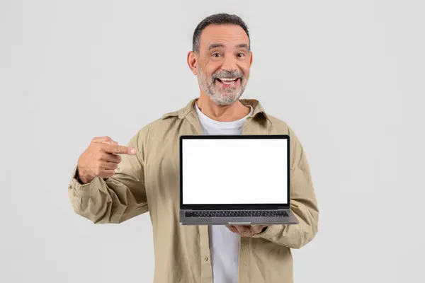 Vrolijke Volwassen Man Presenteren Een Laptop Met Een Leeg Scherm — Stockfoto