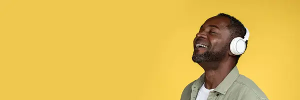 Смеющийся Красивый Афроамериканец Средних Лет Повседневной Одежде Беспроводными Наушниками Наслаждается Лицензионные Стоковые Фото
