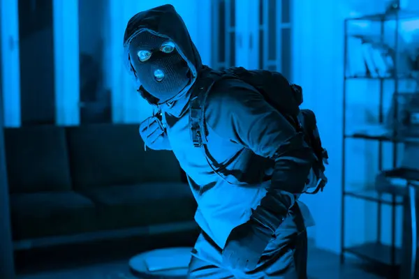 Sinister Figure Ski Mask Backpack Sneaks Dimly Lit Home Suggesting — Stock Photo, Image