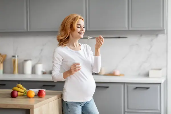 Cheerful European Pregnant Woman Tasting Yogurt Contemporary Kitchen Emphasizing Healthy — Stock Photo, Image