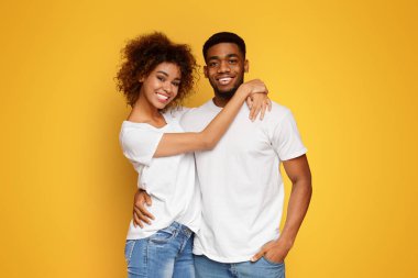 Mutlu ilişkiler. Turuncu stüdyo arka plan, boş alan kucaklayan neşeli afrikalı amerikalı erkek ve kadın