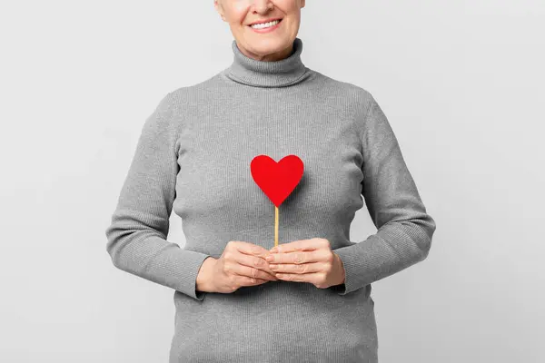 Elderly European Woman Smiles Holding Heart Conveying Love Affection Image — Stock Photo, Image