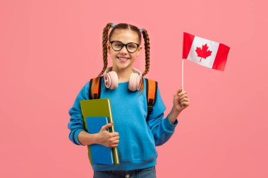 Parlak bir genç kız Kanada bayrağını tutuyor, Kanada kültürüyle bağlantısını ya da pembe izole edilmiş bir ortamda çalışmalarını tasvir ediyor