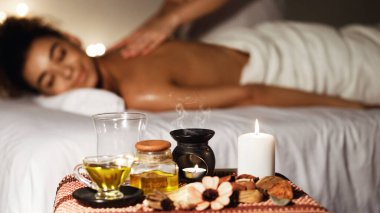 Afrikalı kadın ön planda mumlar ile lüks spa aromaterapi masajı zevk