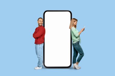 A man and woman stand back-to-back with a giant, blank smartphone screen between them on a blue background clipart