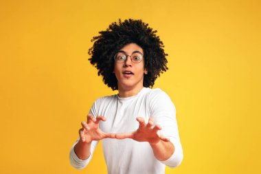 Duygusal Afrikalı adam kamera sihirbaz gibi el sallayarak, turuncu arka plan