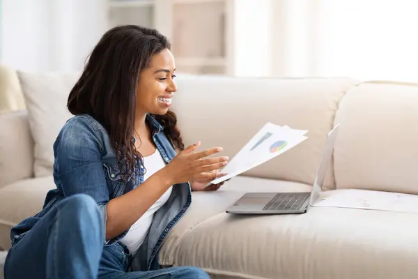 African American Woman Seated Couch Engrossed Reading Paper Focused Content — Stock Photo, Image