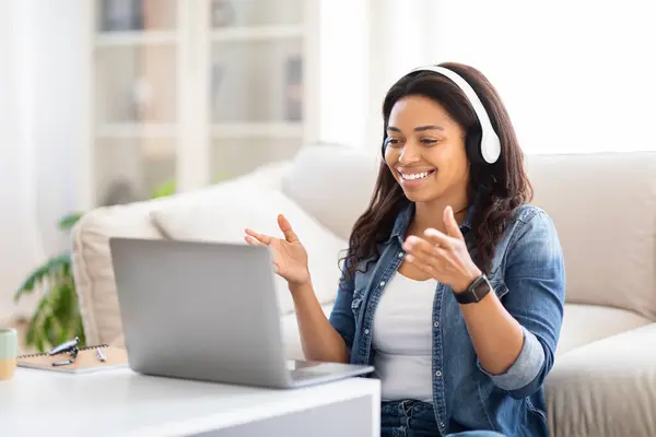 Усміхнена Чорна Жінка Сидить Бежевому Дивані Ноутбуком Відкритим Перед Нею Ліцензійні Стокові Фото