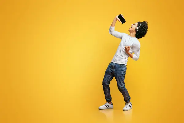 Emocjonalne Młody Czarny Człowiek Śpiewa Swoją Ulubioną Piosenkę Pomocą Smartfonu Zdjęcia Stockowe bez tantiem
