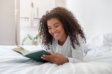 İspanyol kadın bir yatakta rahat bir şekilde uzanıyor, okuduğu bir kitaba dalmış. Sahne onun rahat duruşunu yakalıyor ve sayfalara odaklanıyor..