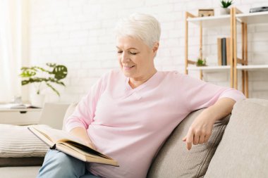 Gülümseyen yaşlı kadın evde kitap okuma, ücretsiz emeklilik zamanı zevk, boş alan
