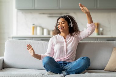 Afro-Amerikalı bir kadın evinde kulaklıkla müzik dinlerken bir anlık neşeyle yakalandı.