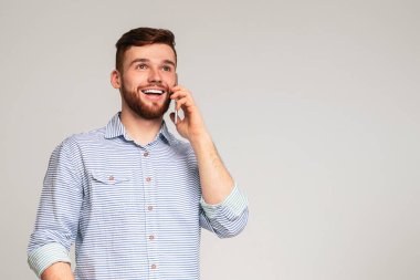 Harika haberlerim var. Neşeli adam onun telefon kullanarak ve yaygın stüdyo arka planda gülümsüyor, Panorama, boş alan