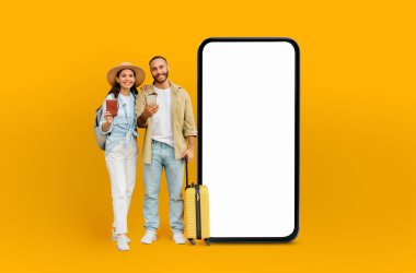 Heyecanlı bir çift, dijital tasarım uygulamaları, çevrimiçi teklifler, teknoloji gösterileri ve yaratıcı izole kavramlarla büyük bir boş akıllı telefon ekranı ile etkileşime giriyor.