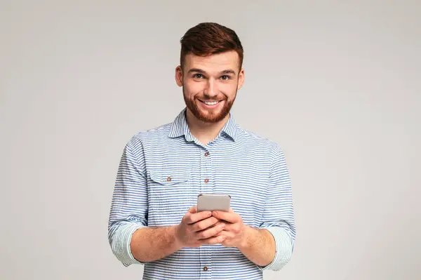 彼の携帯電話を使用して スタジオの背景 パノラマ コピースペースに笑顔を使用して若いひげの男 ストック写真