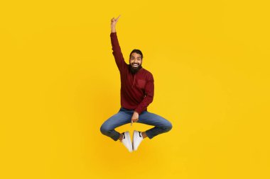 Hintli adam kollarını kaldırarak atlarken havada yakalanır. Heyecan ve enerji gösterisi yapar. Eylem, bu dinamik anda bir sevinç ve kutlama hissi veriyor..