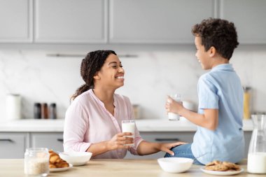 Güneşli bir mutfakta, Afrikalı bir Amerikalı anne ve küçük oğlu kahvaltı sırasında bir anı paylaşıyor, aile ve beraberlik kavramını somutlaştırıyor.