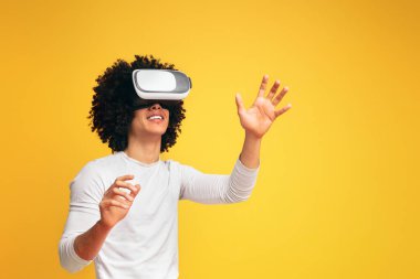 Heyecanlı genç siyah adam sanal gerçeklik gözlük deneyimi, turuncu stüdyo arka plan zevk