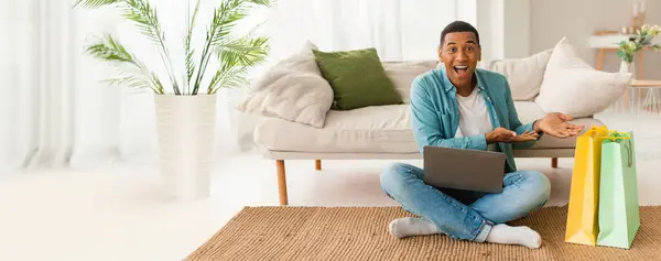 Alışveriş Torbaları Dizüstü Bilgisayarı Olan Neşeli Bir Afro Amerikalı Adam — Stok fotoğraf