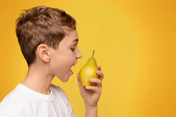 Healthy Organic Snack Teen Boy Biting Fresh Pear Orange Studio — Stock Photo, Image