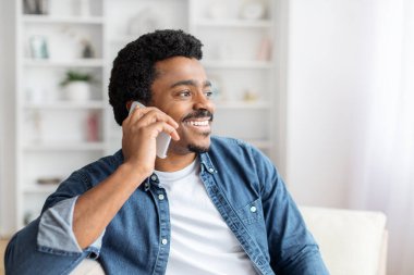 Görüntü bir bağlantı hissi veriyor, Afrikalı bir Amerikalı bir telefon görüşmesine cevap veriyor, potansiyel olarak kendi evinde önemli konuları tartışıyor.