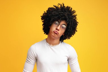 Komik üzgün Afrikalı adam dudakları pouting, rahatsız görünümlü, turuncu arka plan