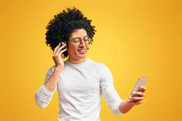 Velger Neste Låt Munter Ung Afritisk Mann Med Hodetelefoner Som stockbilde