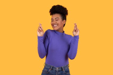 Hispanic woman wearing a purple shirt is gesturing with her hand in a clear and deliberate manner, cross fingers. Her expression is focused, indicating intent behind the gesture she is making. clipart