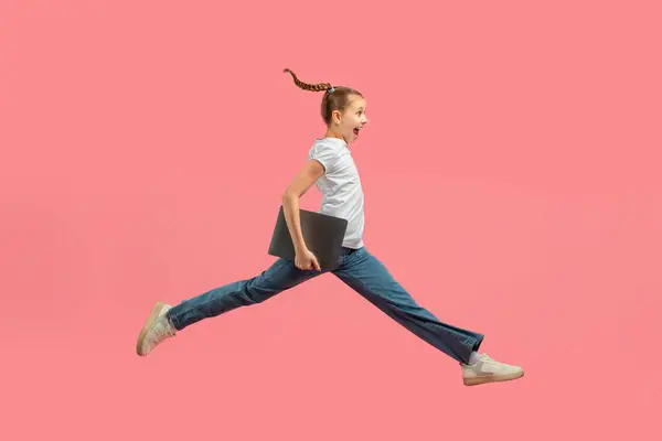 Young Girl Braided Ponytail Captured Mid Air Jump Pink Background — Stockfoto