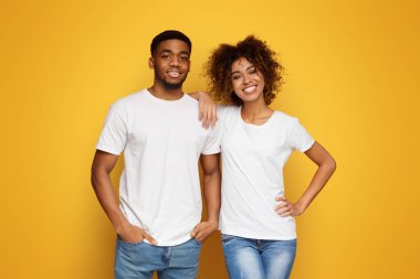 Mutlu çift. Turuncu stüdyo arka planda gülümseyen Afrikalı-Amerikalı erkek ve kadın