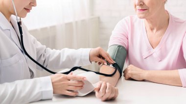 Kadın doktor kadın kıdemli sağlık kavramı kan basıncı ölçme