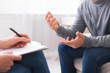 Psikoterapist notlar yazma, hastaların sağlığını değerlendirmek ve danışmanlık oturumu sırasında kanepede oturan adama tanı koymak , panorama, boş alan