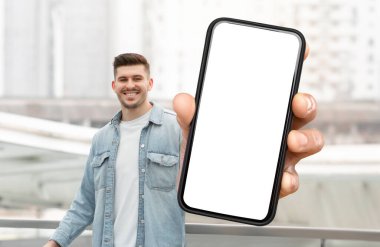 Bir adam elinde beyaz ekranlı akıllı bir telefon tutuyor. Arka plan tarafsız, adama ve elindeki teknolojiye odaklanmış durumda..