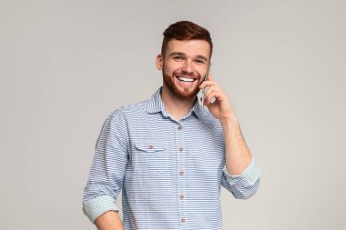 Mutlu Milenyum Adamı Cep Telefonuyla Konuşuyor Gülümsüyor, bej arka plan, serbest alan