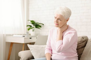 Olgun kadın evde sırt ağrısı muzdarip, el ile boyun masaj, bitkin, boş alan hissi