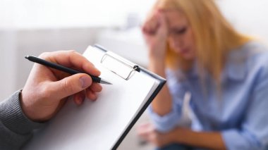 Psikolojik teşhis. Profesyonel usta psikolog notlar alarak, hastasını dinlerken, boş alan