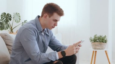 Online pokeri kaybetmek. Milenyum çocuğu evde cep telefonuyla video oyunu oynuyor.