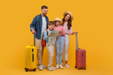 İki yetişkin ve iki çocuğu olan neşeli bir aile bir yolculuğa hazırlanıyor. Ebeveynler bavullarıyla ayakta dururken, çocuklar bir haritanın etrafında toplanmış, sarı stüdyo arka planı.