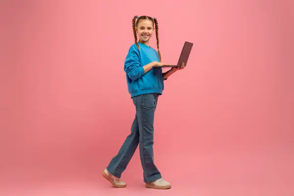 Young Girl Walking While Holding Laptop Her Hands She Appears Royalty Free Stock Images