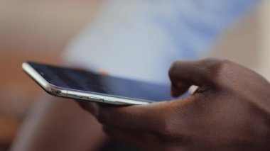Modern cep telefonu kullanarak siyah erkek ellerini kapat.