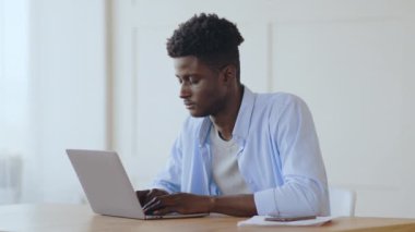 İşe ara verelim. Genç Afrikalı yönetici dizüstü bilgisayardaki projeyi bitirdikten sonra işyerinde dinleniyor