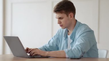 Bilgisayar sorunları. Evde yazılım hatası olan öfkeli bir adam dizüstü bilgisayara bağırıyor.