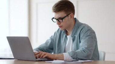 Uzak iş ve problem çözümleri. Ofiste dizüstü bilgisayarla çalışan düşünceli bir adam.