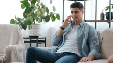 Genç adam telefonda konuşuyor, evde dinleniyor, boş yer var.